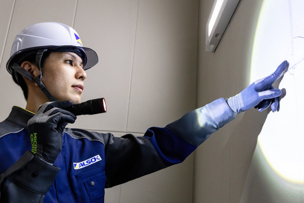 青い海と緑に囲まれた沿岸部に立つ原子力発電所の全景と、手前にかかる橋。